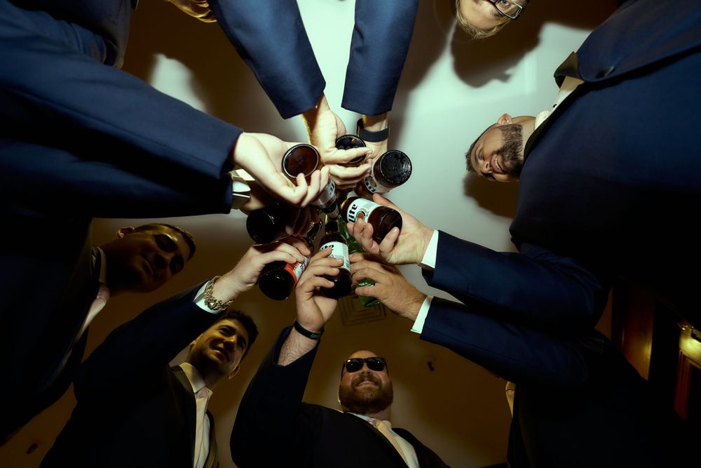 Low angle view of hands holding drinks together in a celebratory toast.