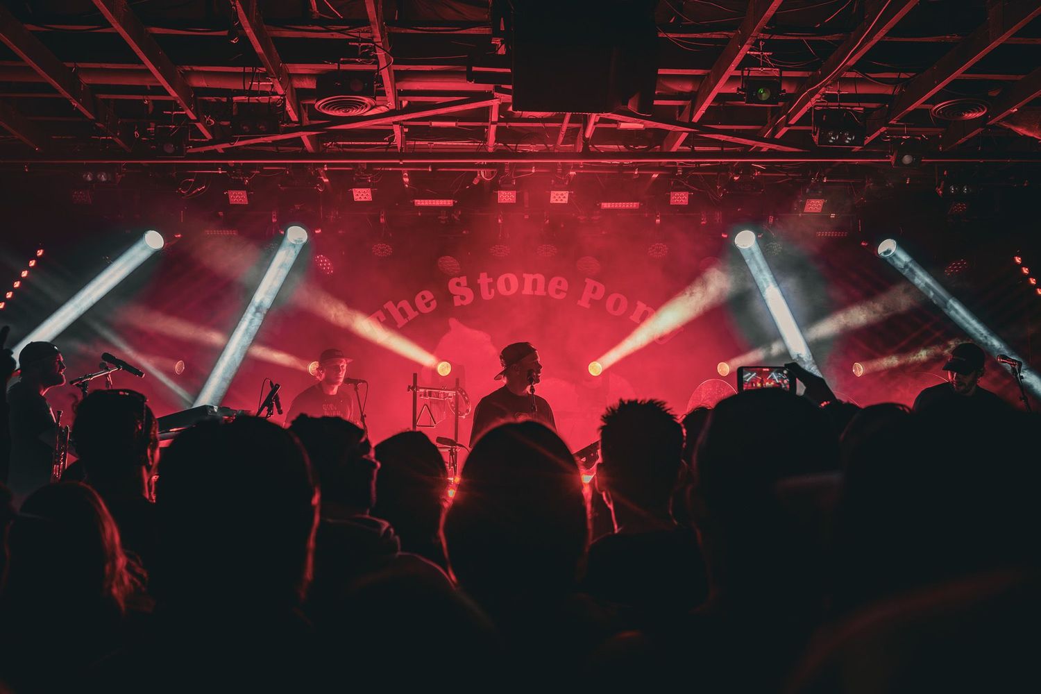Live music photography of The Movement performing on stage under red lights and spotlights at The Stone Pony in New Jersey.