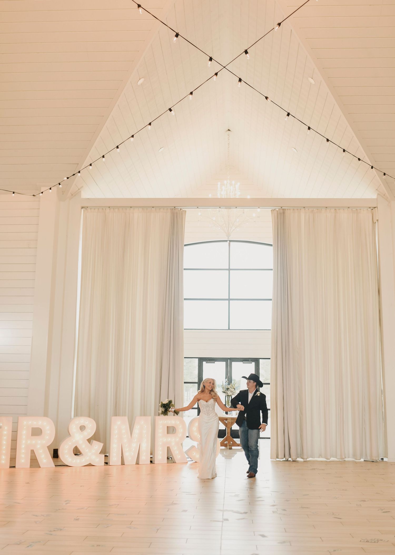 Bride and groom enter reception surrounded by applause from loved ones