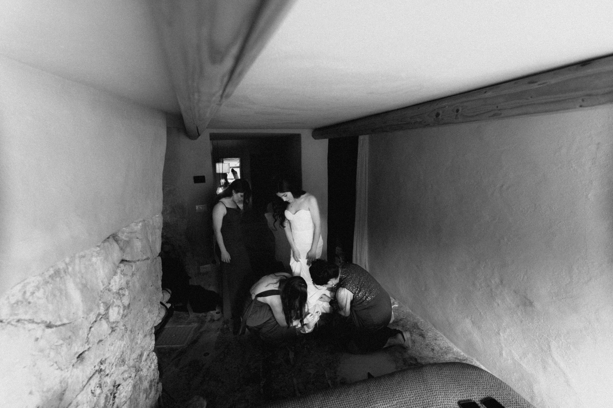 Black and white photo of people crouched in a narrow stone corridor or tunnel passage.