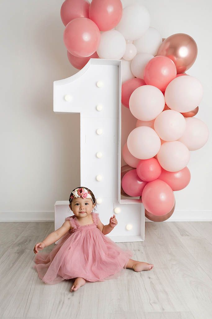 Baby girl in pink birthday dress by Perris baby photographer.