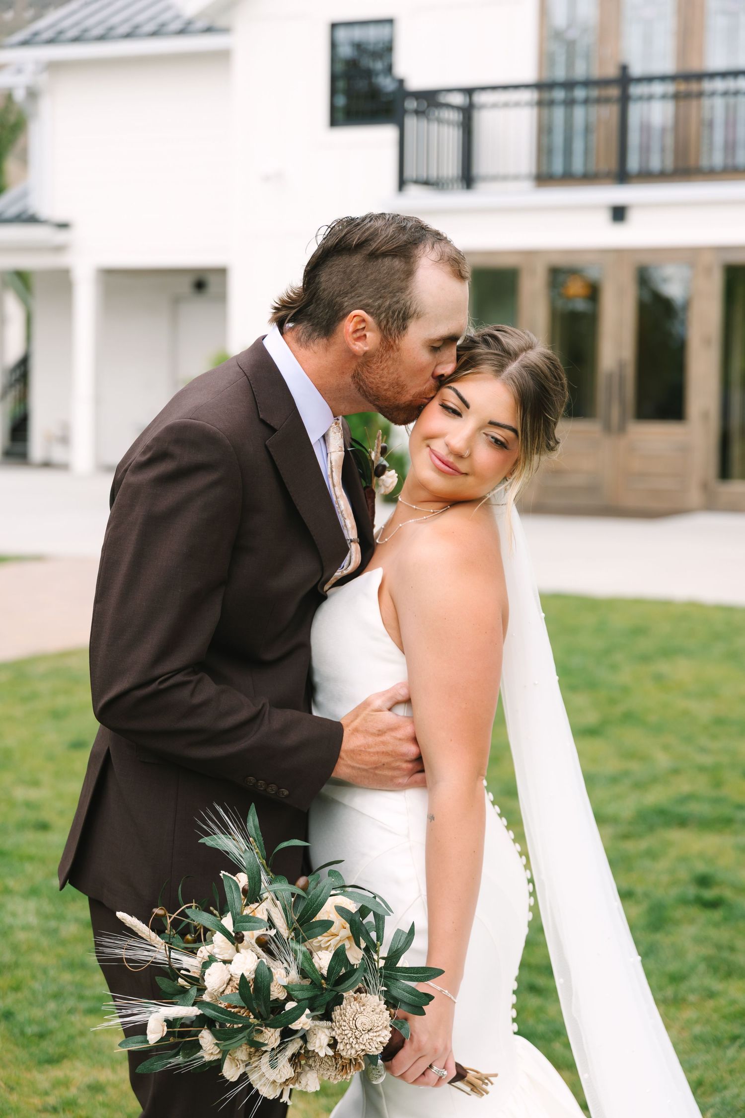 A joyful bride and groom share a quiet moment together on their wedding day, surrounded by beautiful natural light.