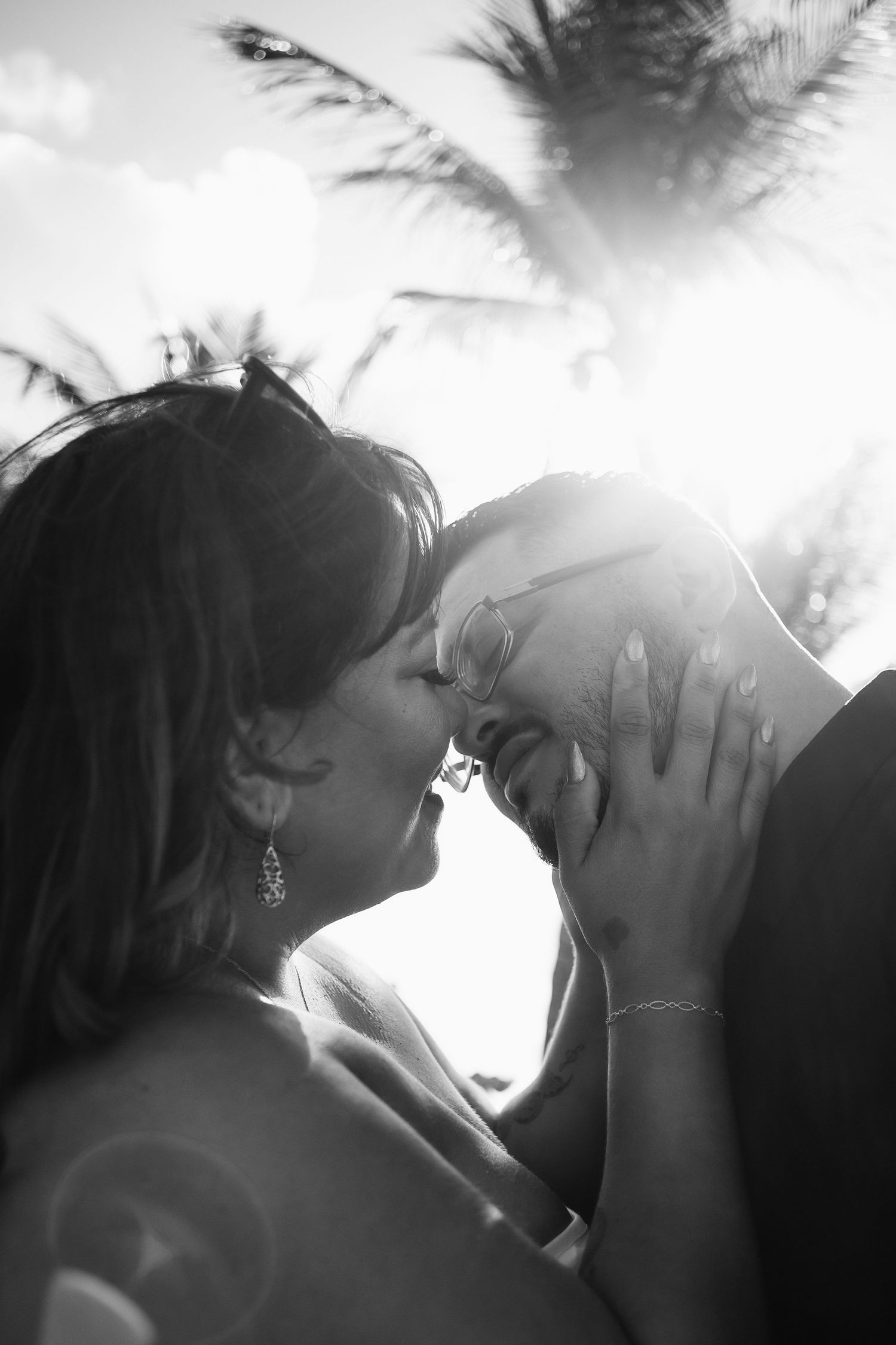 Couple kissing at Pompano Beach Pier during engagement couples session.