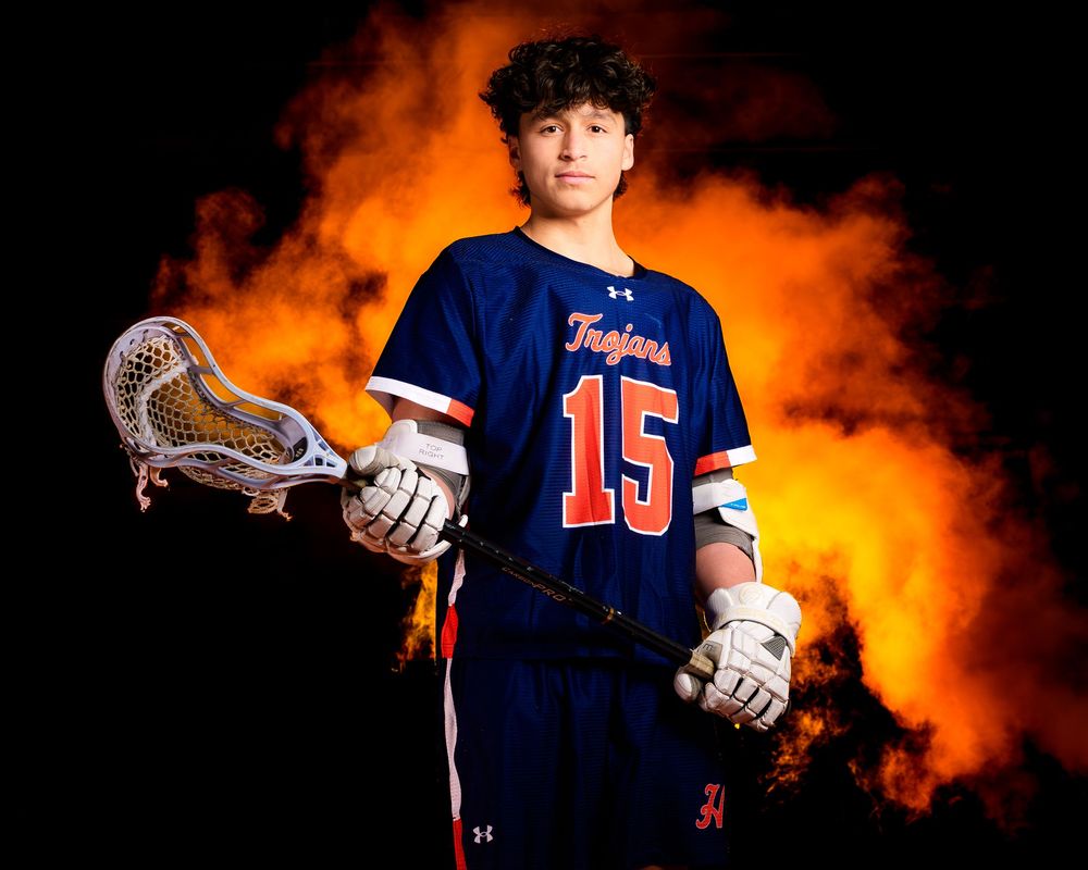 Hershey High School lacrosse senior #15 media day portrait with orange smoke, by Deanna Fox, SportsFox Photography based in Hershey PA