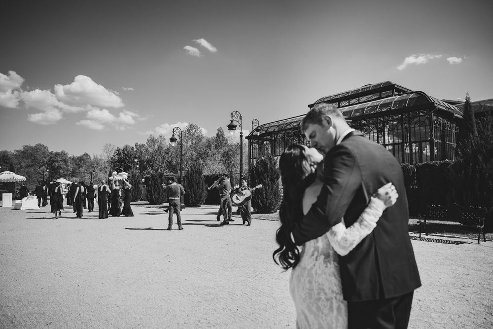 Black and white photo of bride and groom sharing a romantic embrace outdoors at their wedding.
