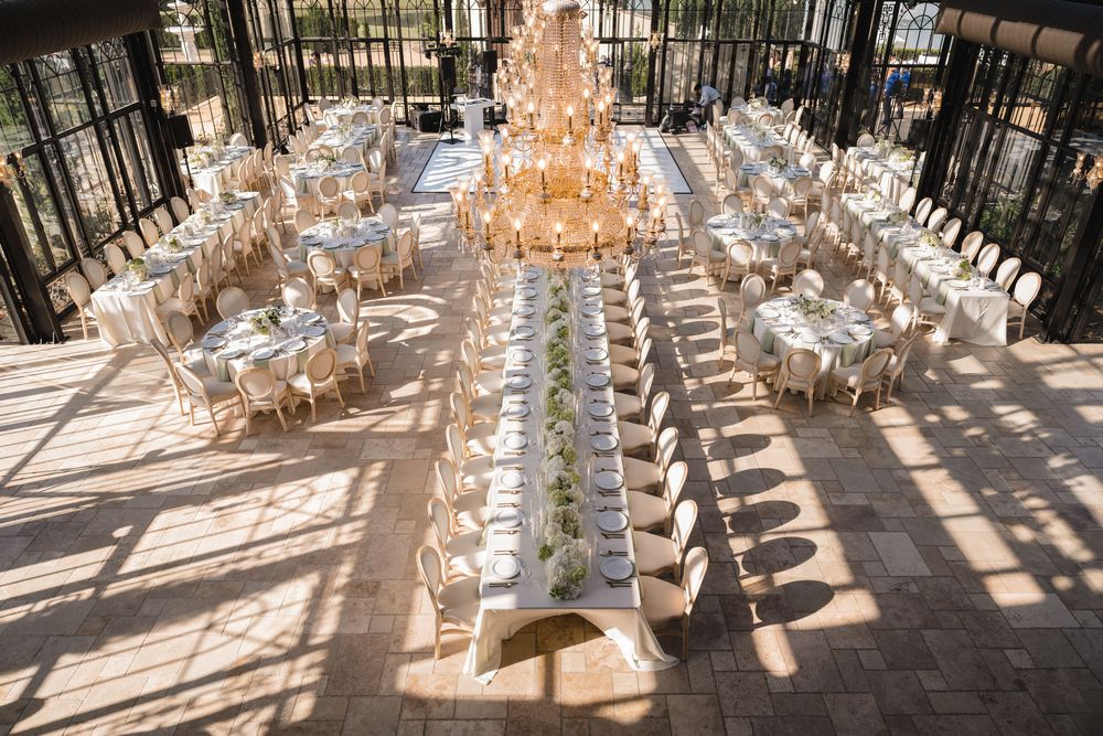 Aerial view of elegant wedding reception with long head table and round guest tables.