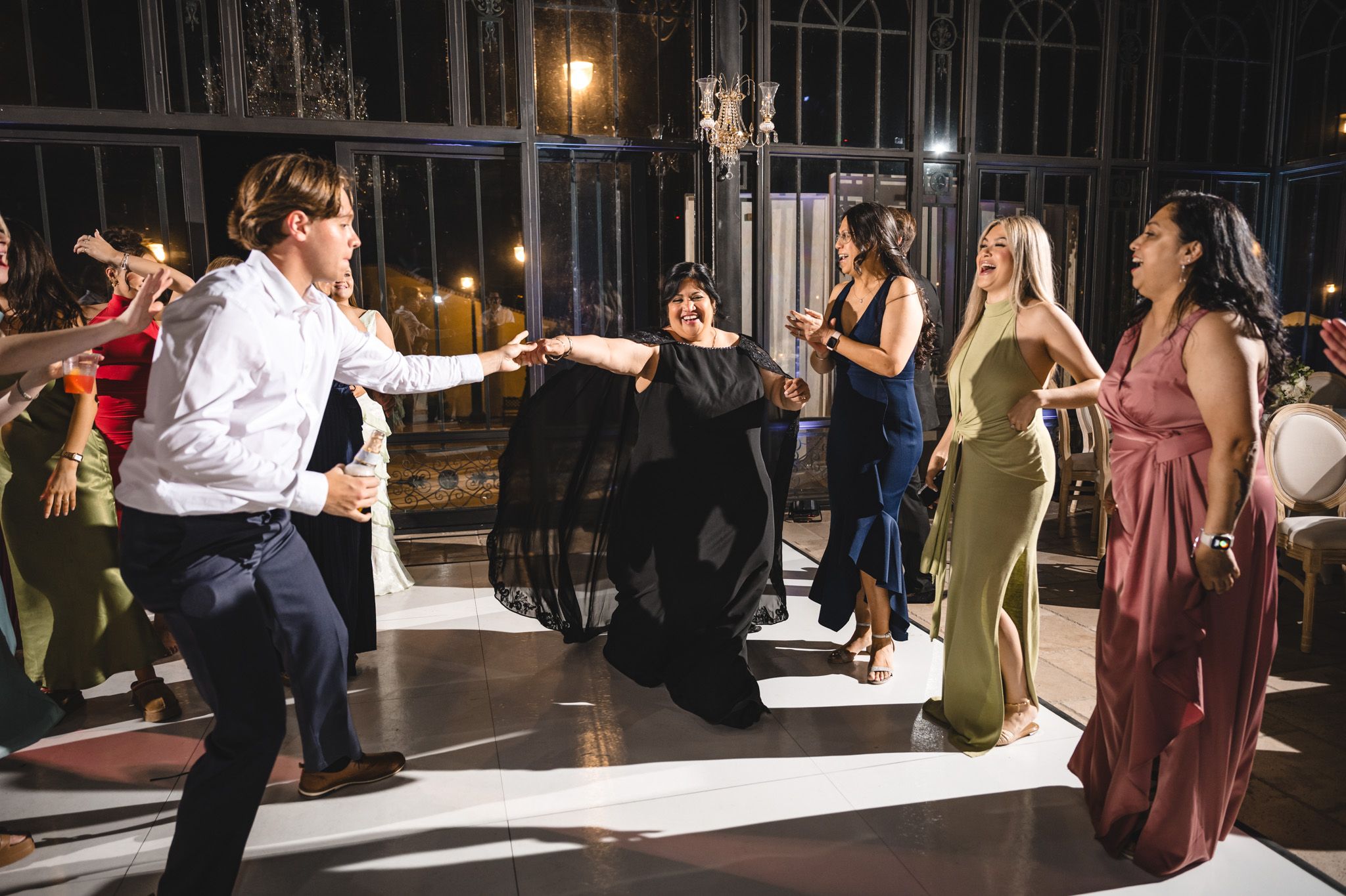 Guests dancing elegantly on the dance floor at a formal wedding reception.