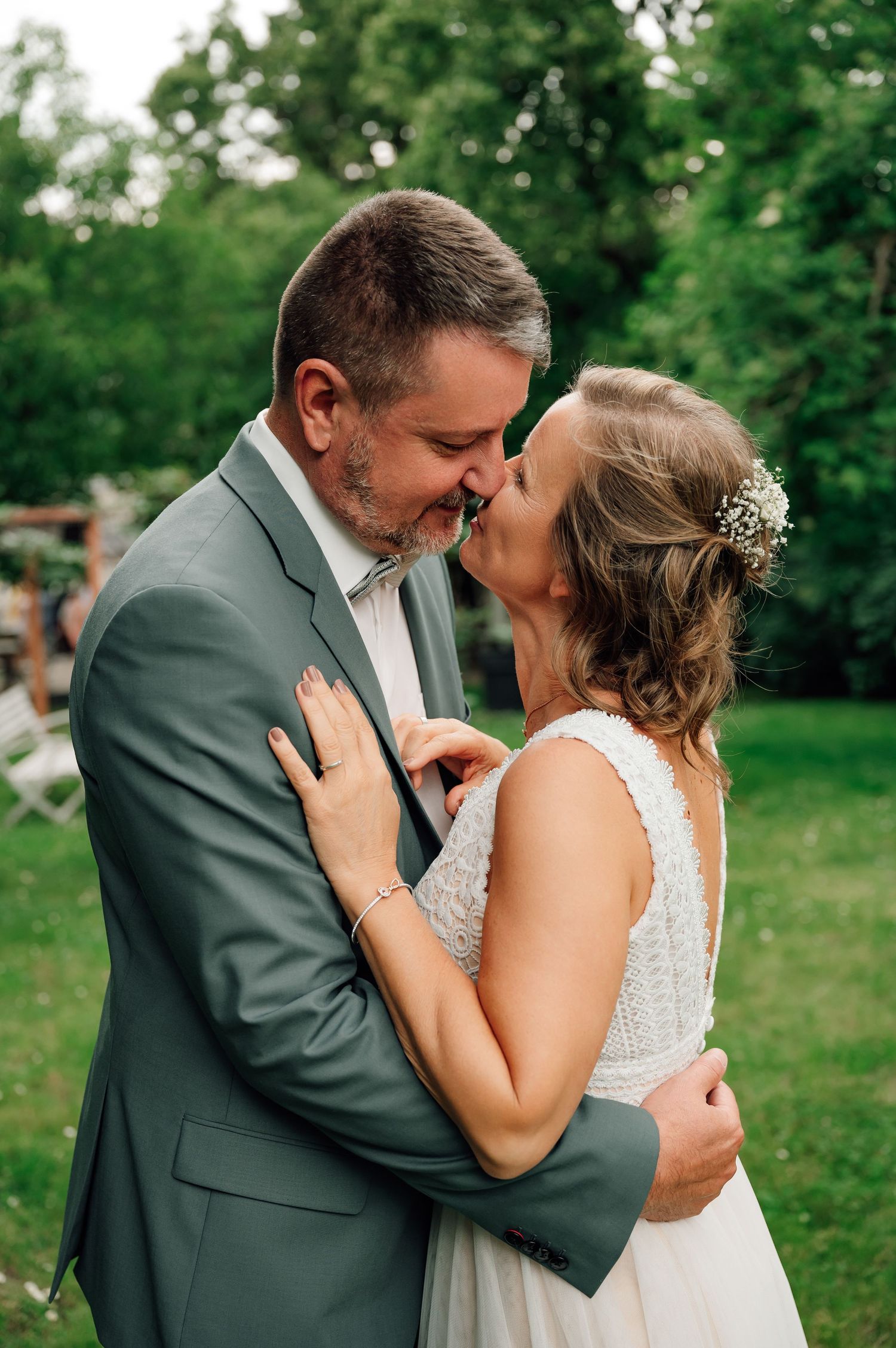 Intimate wedding moment captured in a lush green garden setting.