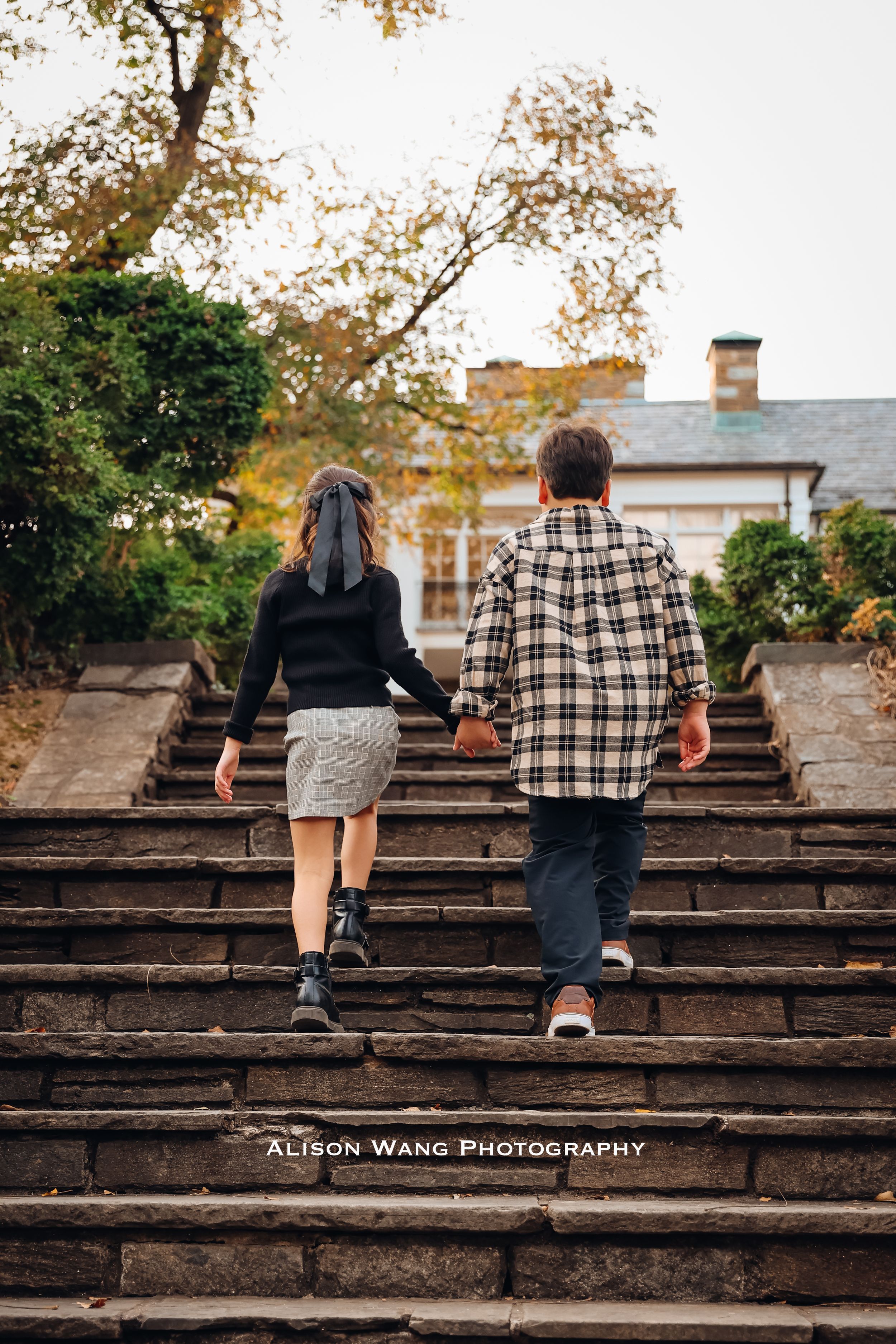 Family walking up weathered stone steps during outdoor photo session.