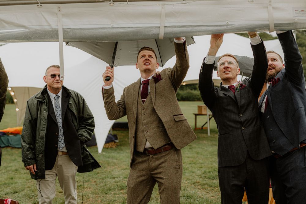 Wedding guests in formal attire gather outdoors on a cloudy day.