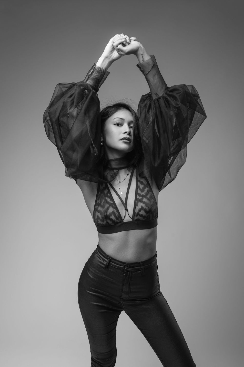 Black and white portrait series showcasing flowing black top and fitted pants.