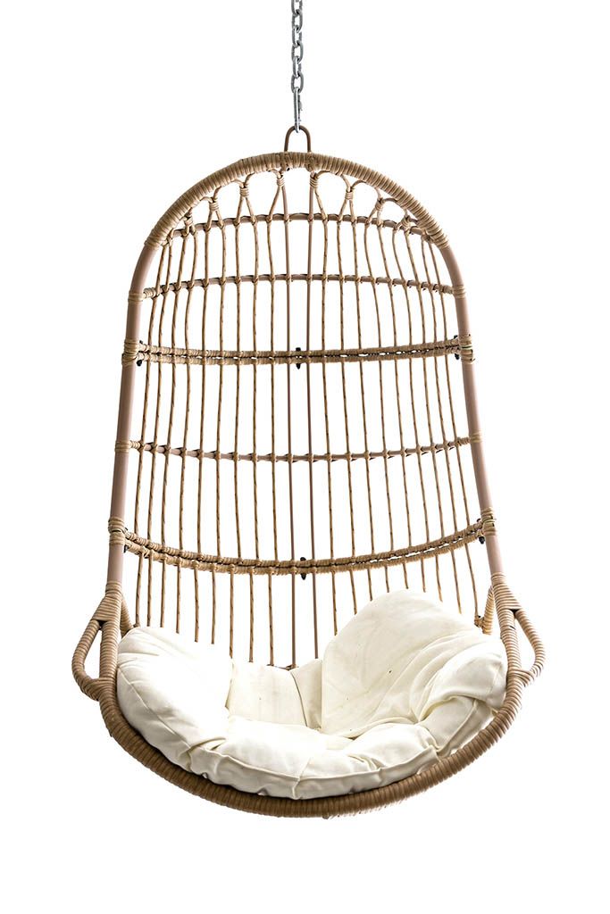 Boho rattan hanging egg chair with white cushion suspended by metal chain on white background.