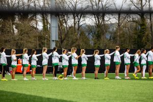 Oregon Ducks women's lacrosse team lines up during pre-game ceremonies on turf field.