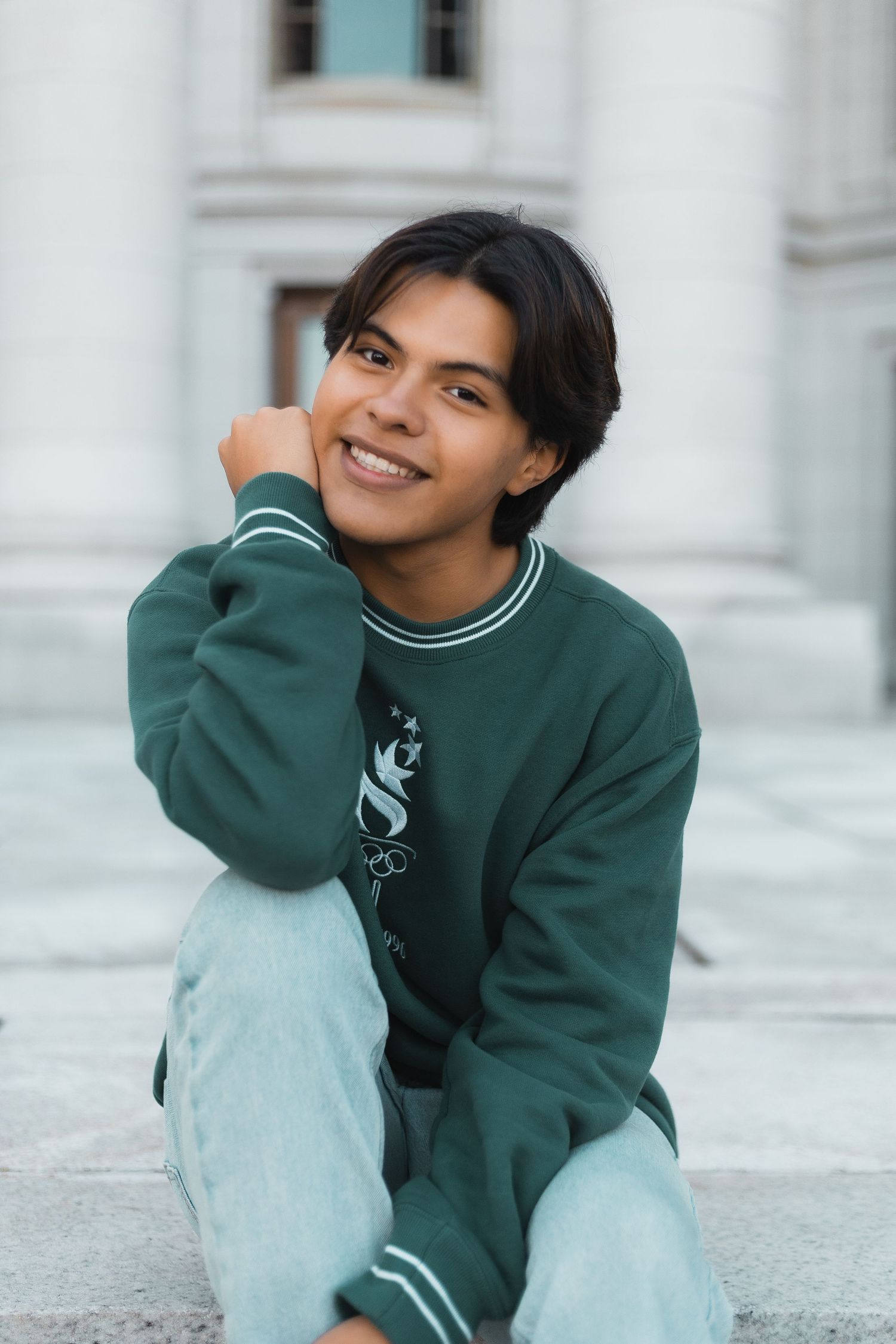 madison wi professional yearbook photos high school senior photographer waste up headshot sitting on wisconsin state capitol steps posing