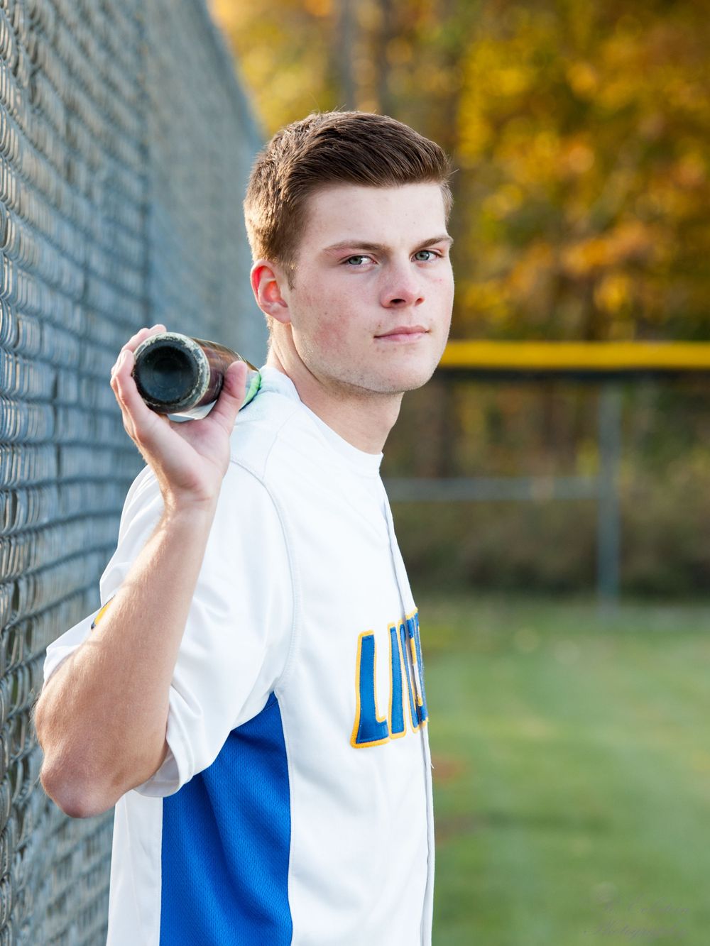 Senior portrait of boy holding baseball bat