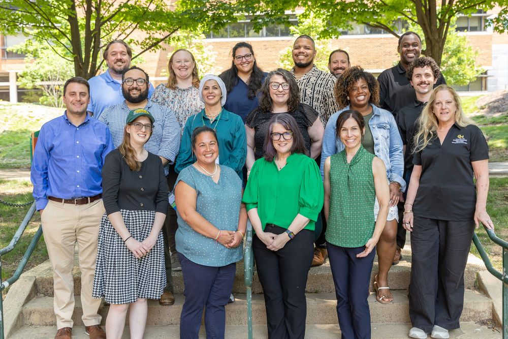 A group photo of business professionals standing together on outdoor steps in casual and business attire.