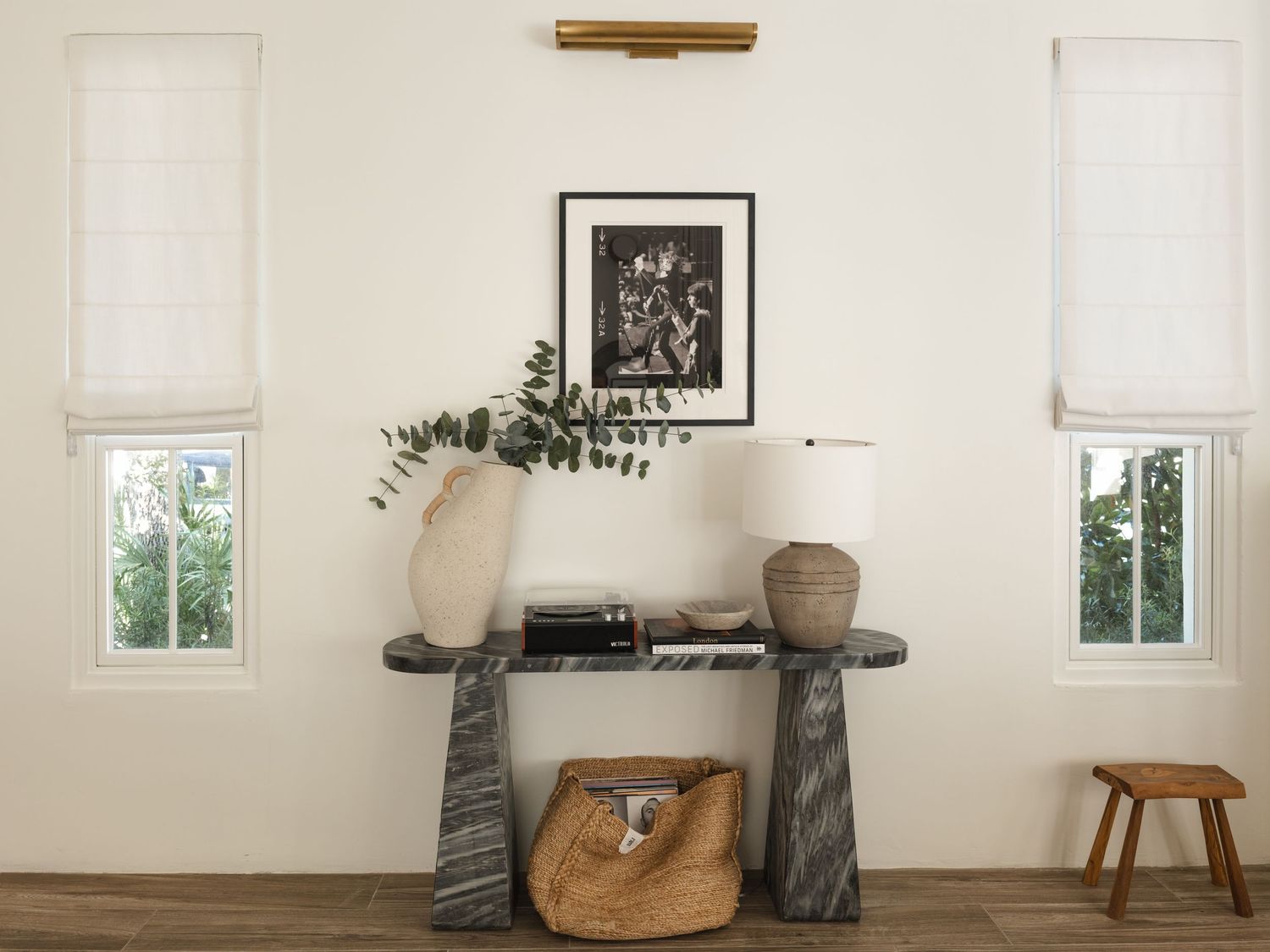 White interior hallway with built-in shelving leading to ocean view through windows.