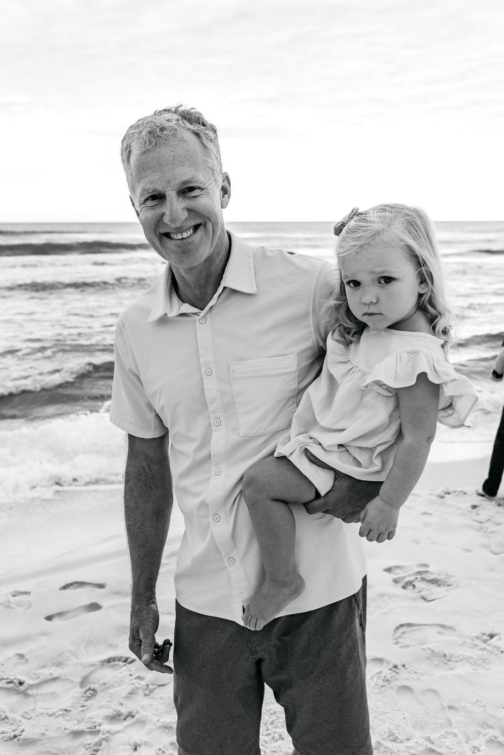 Family portraits on a sunny beach in black and white.