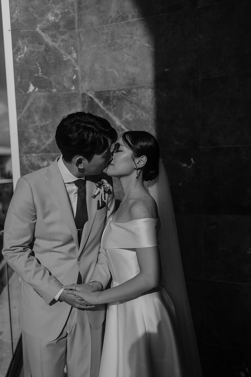 Black and white photo series shows intimate kiss sequence between a couple in formal attire.