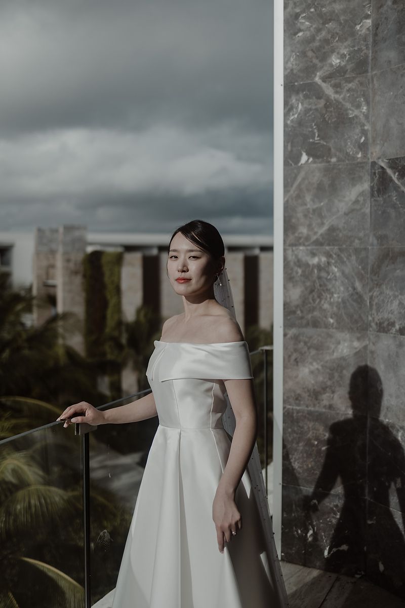 Bride looking through glass balcony, wedding photographer in Cancun.