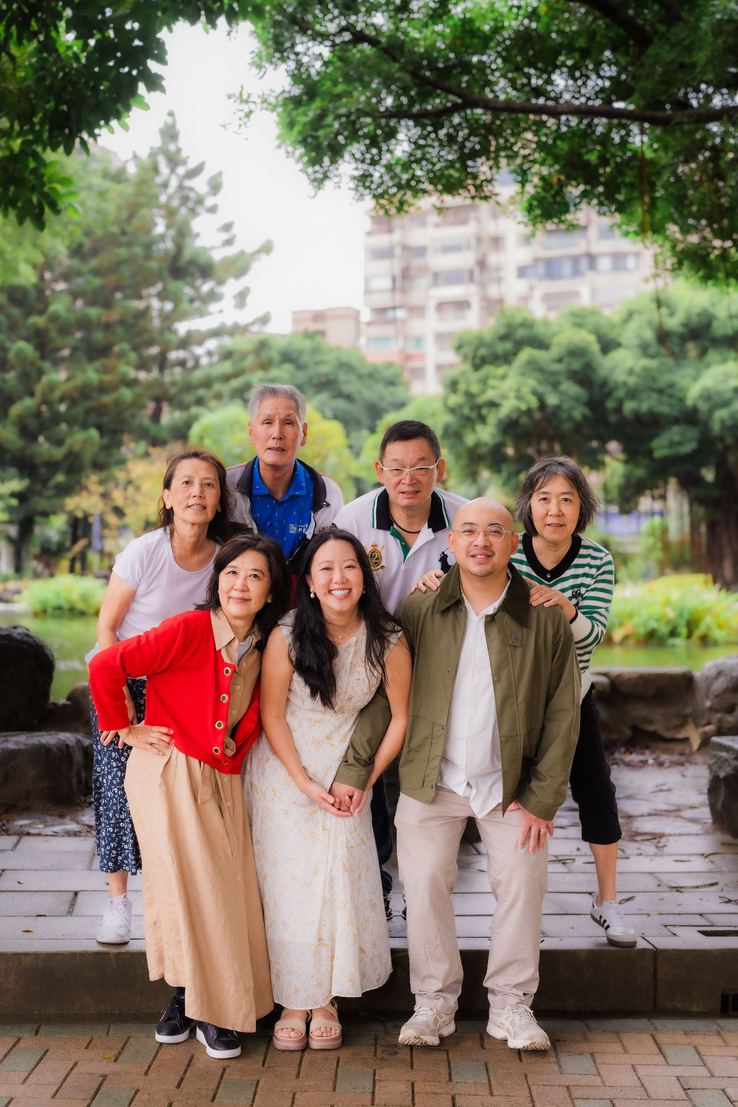 A group of people posing together in a lush green park setting.