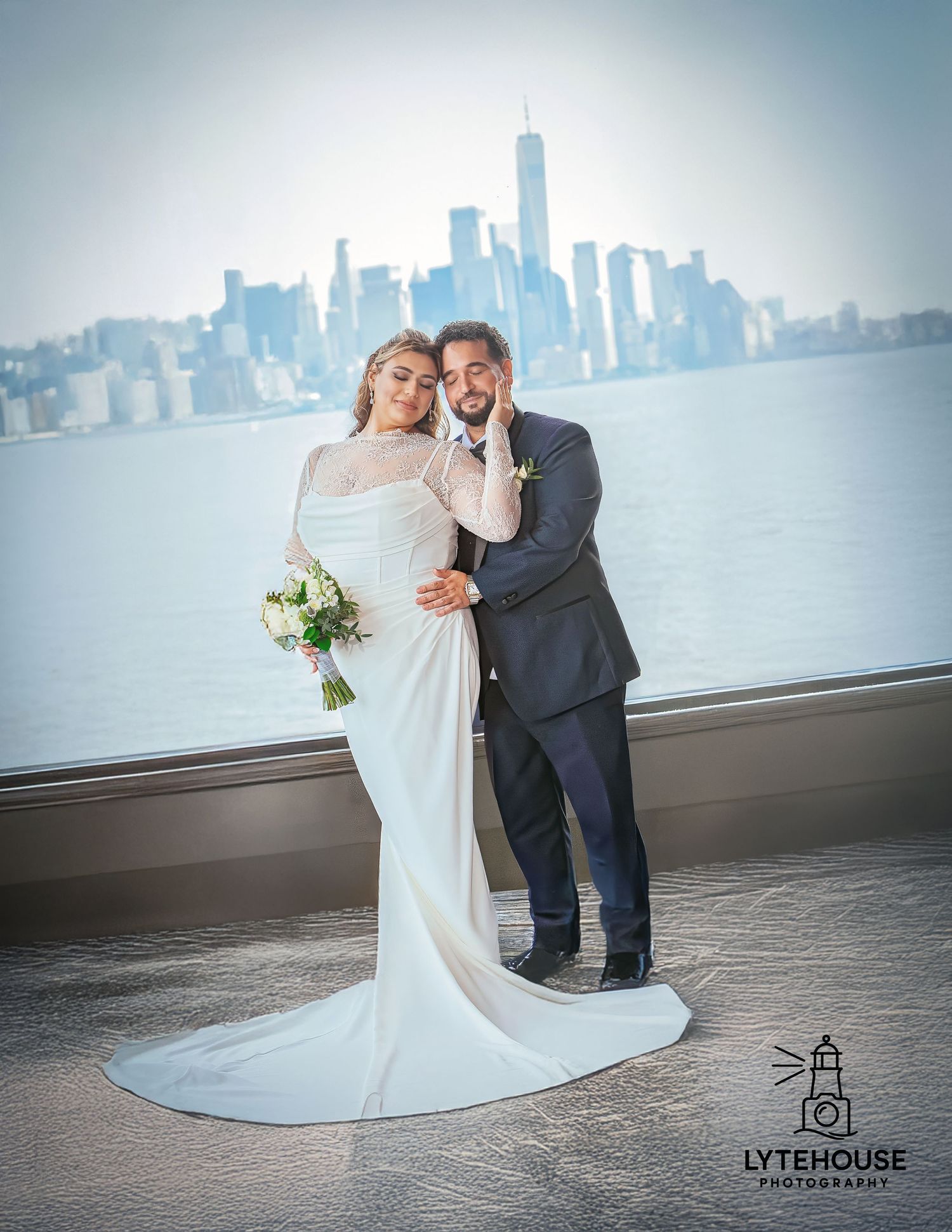 A couple in wedding attire share a romantic moment with the Toronto skyline visible across Lake Ontario in the background.