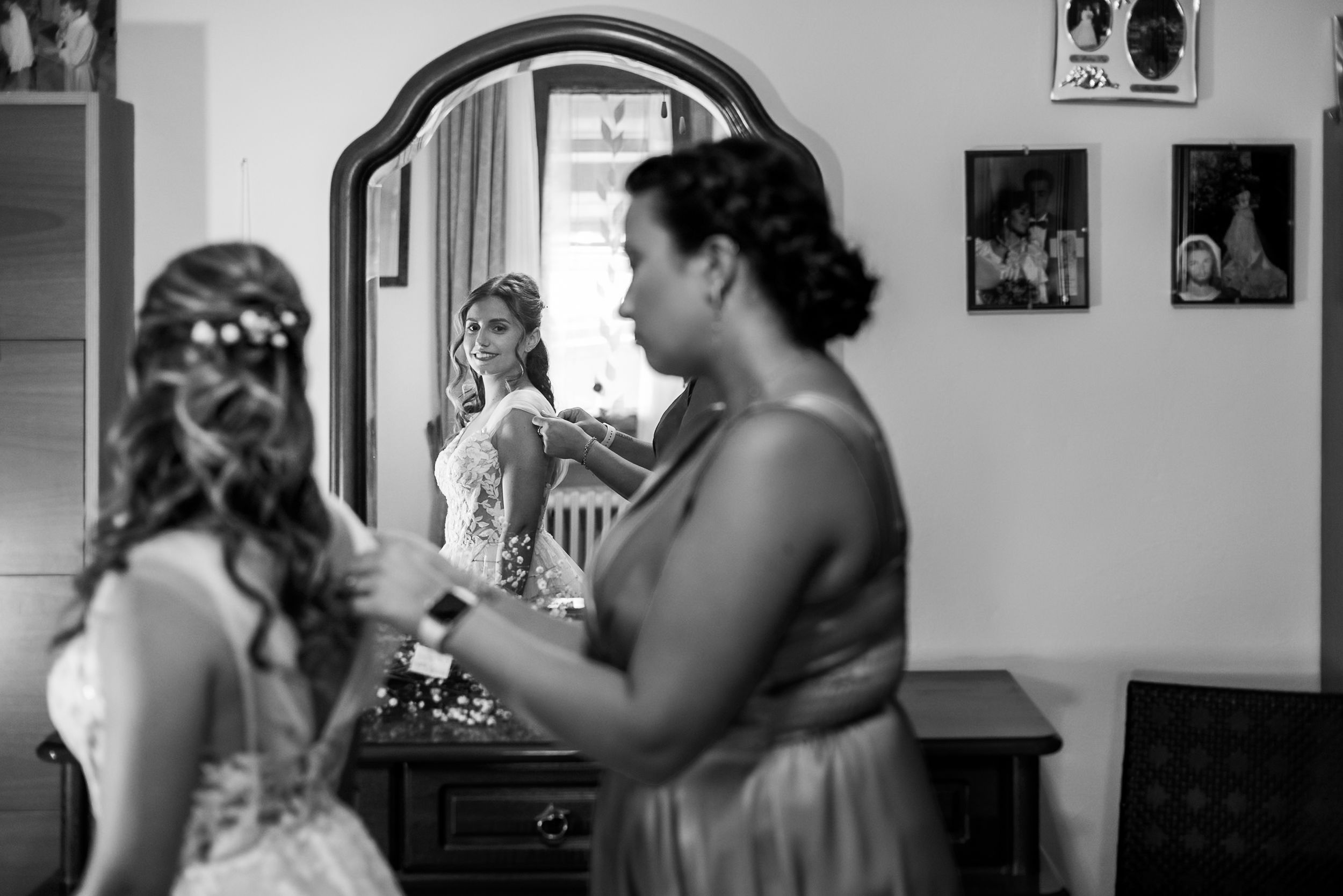 A sequence of black and white wedding photos showing emotional moments and hugs between the bride and loved ones.