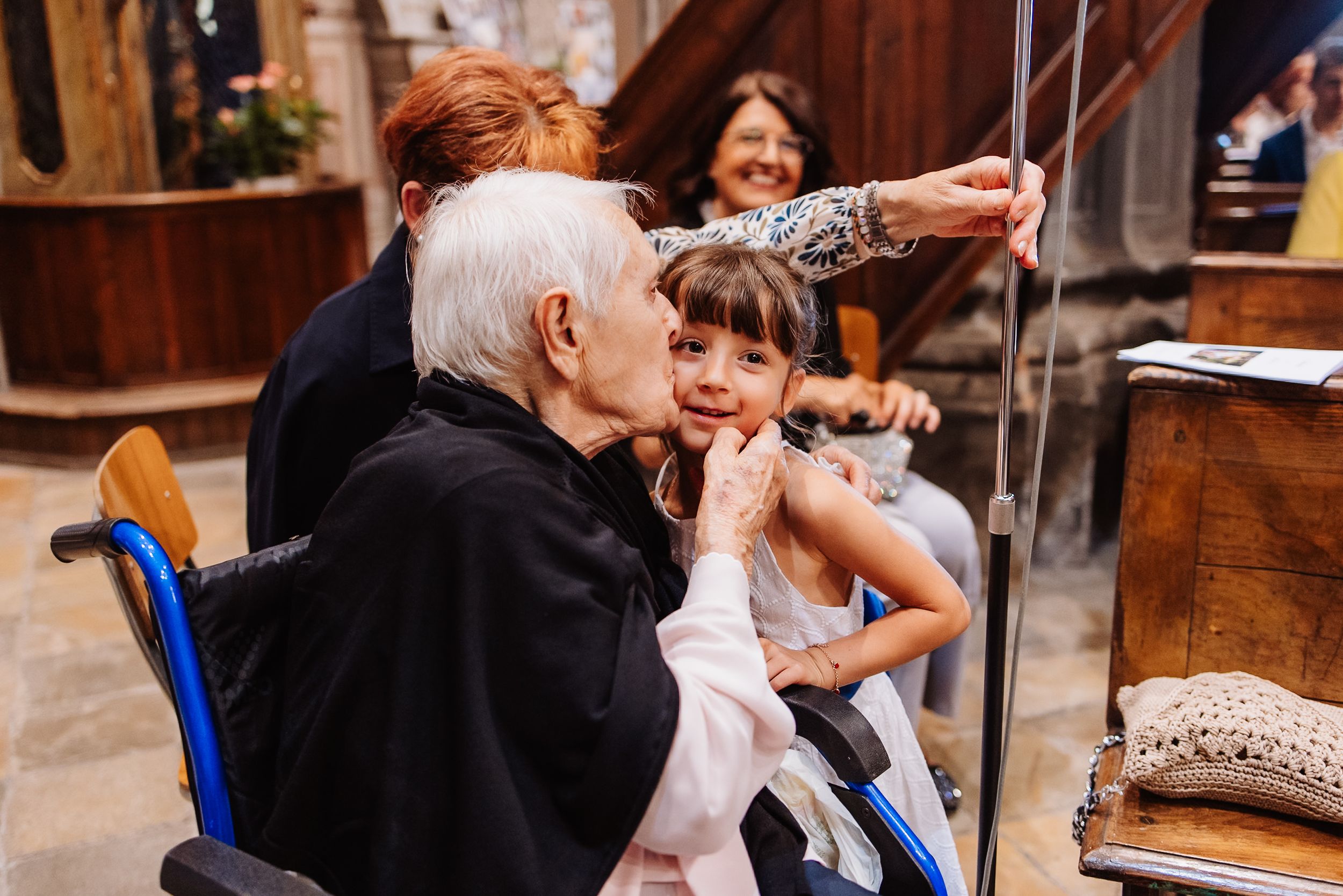 A group of people share laughter during dinner at a rustic wooden table.