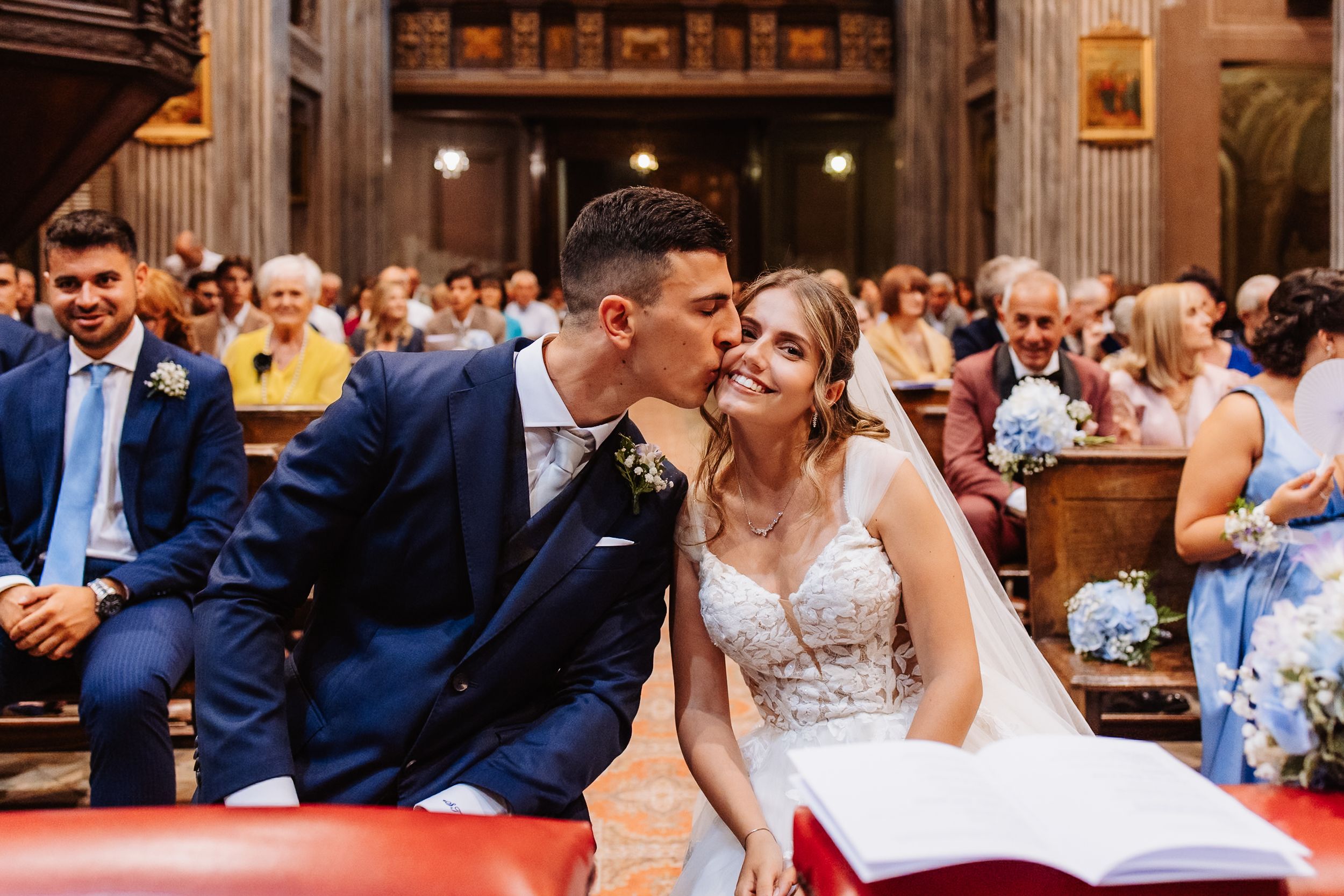 Wedding couple shares an intimate moment during their rustic barn reception celebration illuminated by glowing lights.