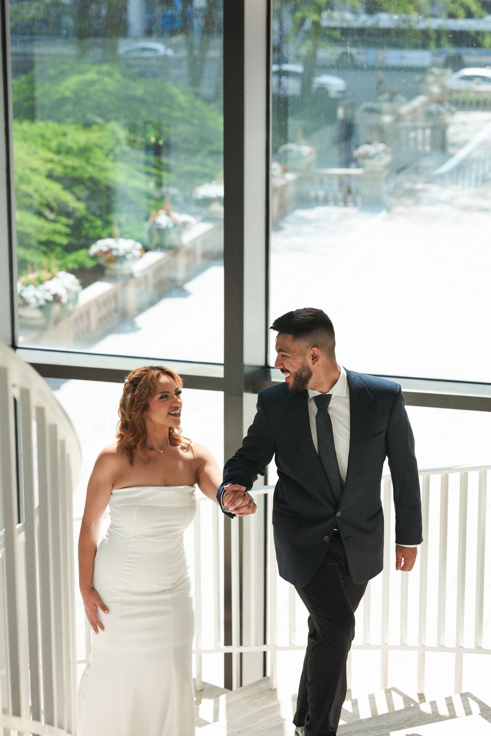 A sequence of candid wedding photos in a bright modern space with glass windows.