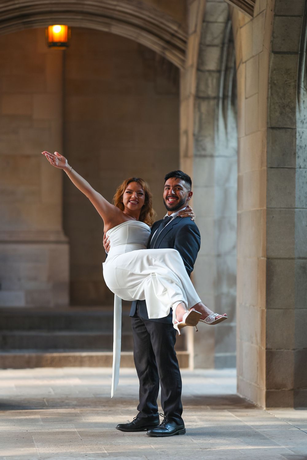 Artistic wedding poses under stone archways with dramatic lighting.