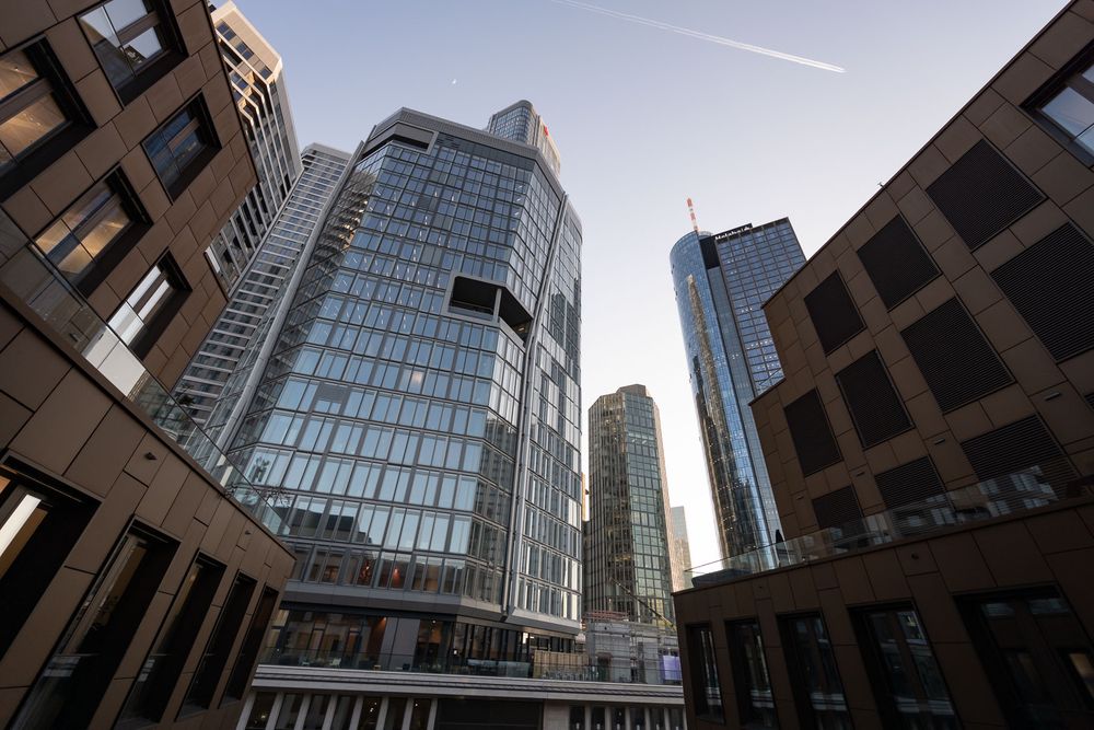 Modern glass skyscrapers and office buildings stretch into the sky in an urban business district.