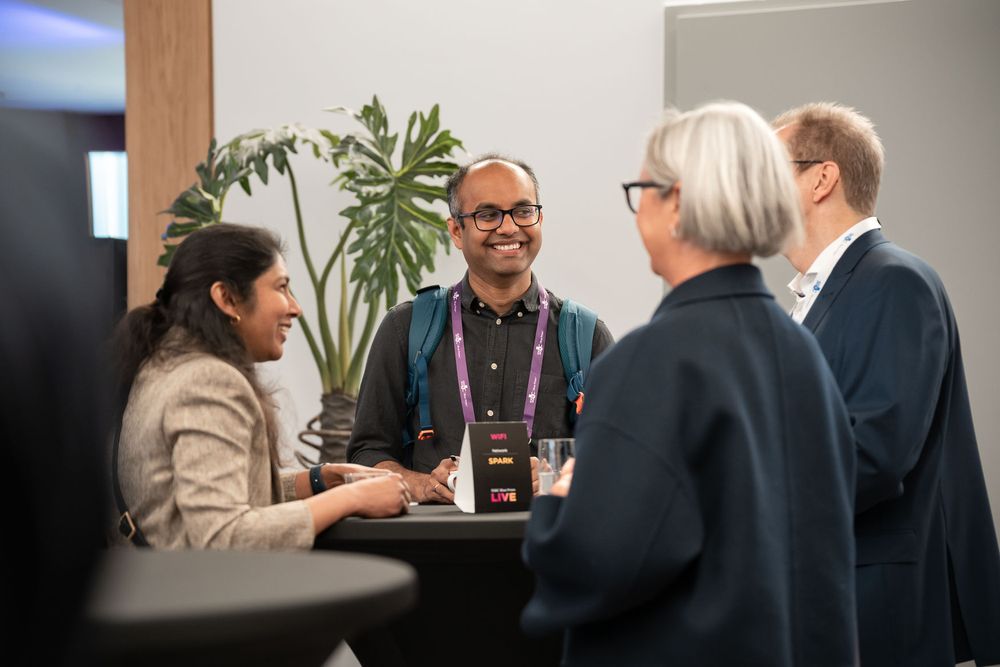 People engaged in focused discussion and networking at a professional conference or business meeting.