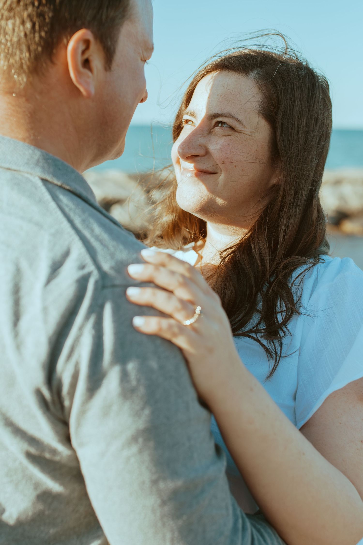 Happy couple in casual attire sharing an intimate moment outdoors.