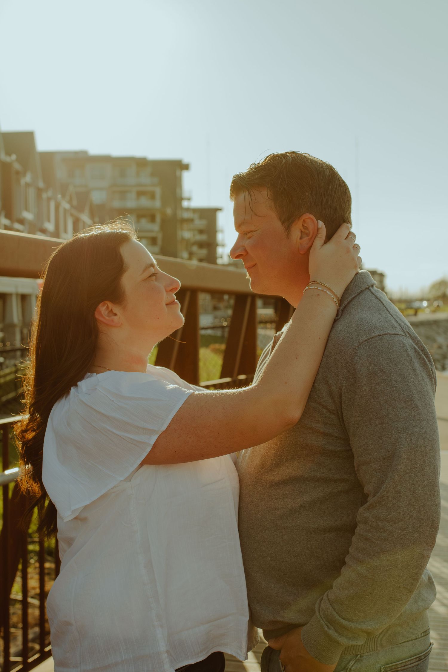 Golden hour portrait of a couple in casual clothes sharing an embrace.
