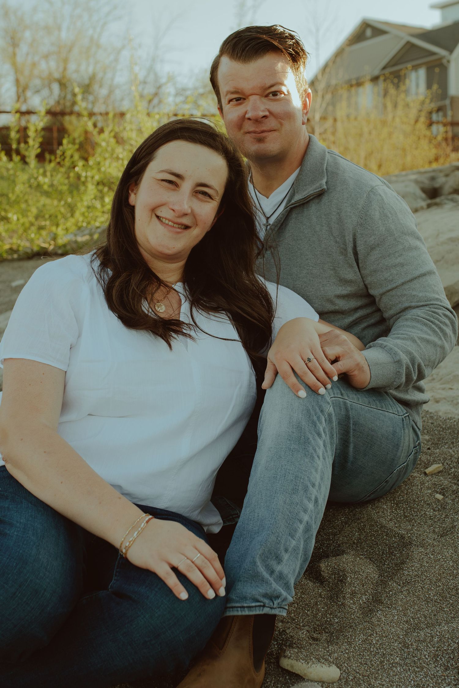 Couple sitting outdoors sharing tender moments during autumn photoshoot.