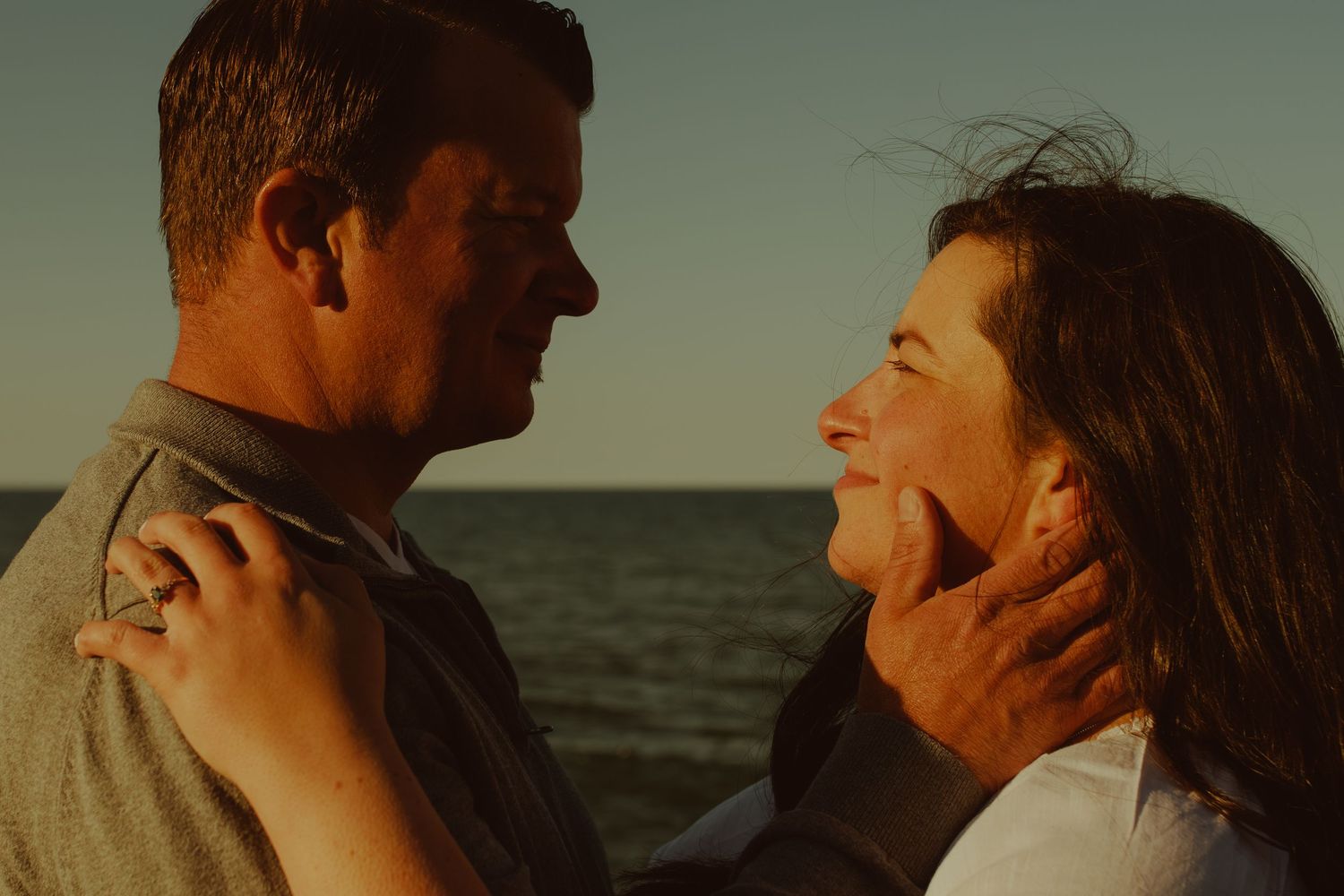 An intimate sunset moment captured between a couple at the beach.