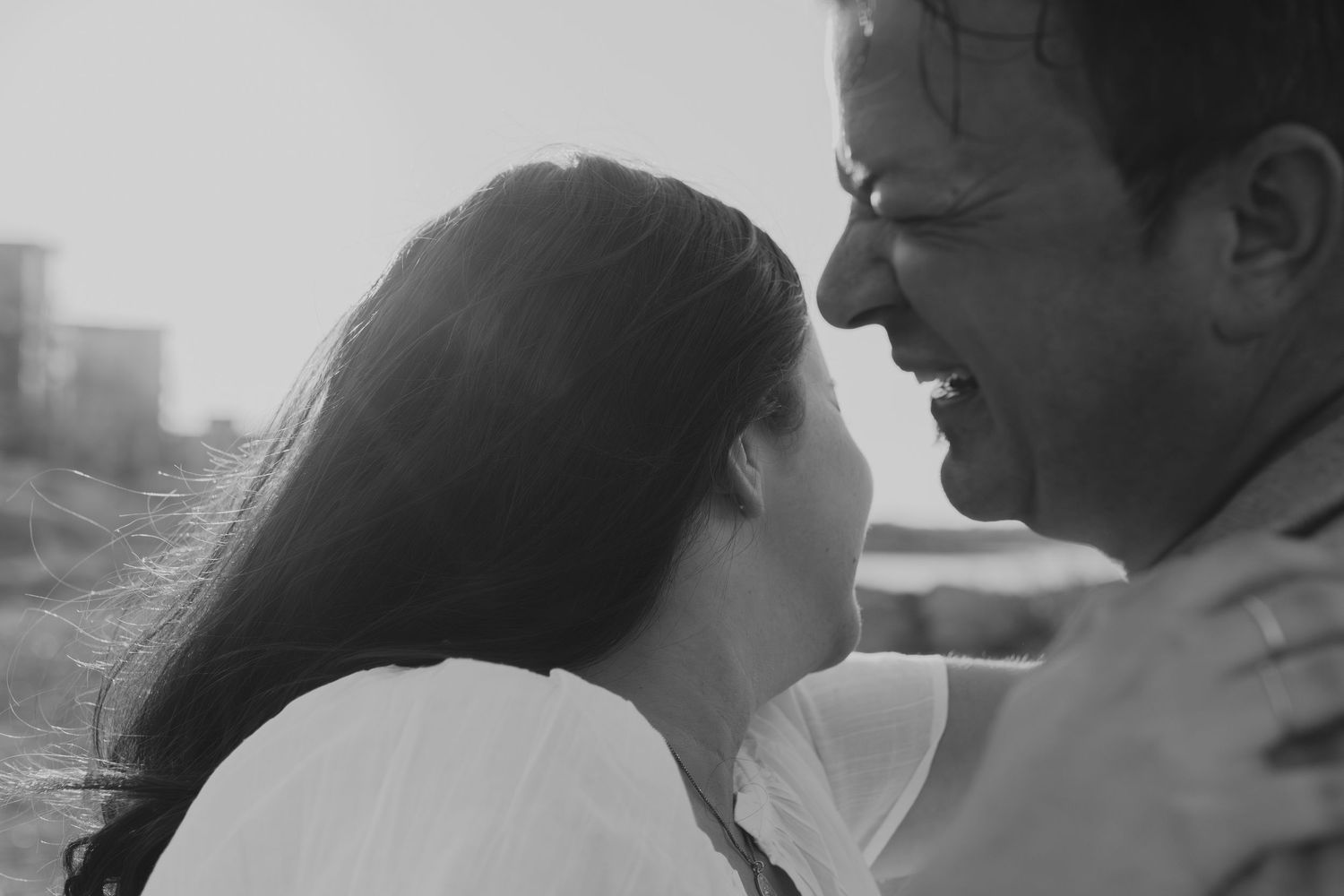 High contrast black and white portrait of a couple in an intimate embrace.