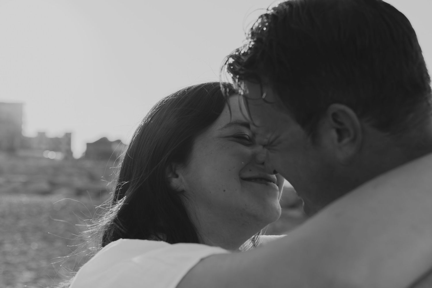 A romantic black and white moment captured between a couple sharing an intimate embrace.