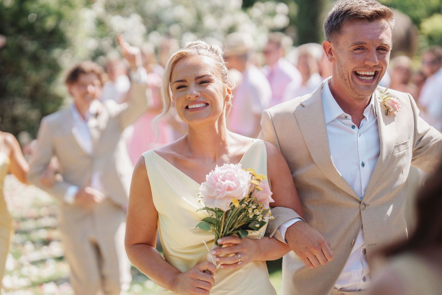 Bridesmaid and best man walking down aisle laughing and enjoying the wedding atmosphere