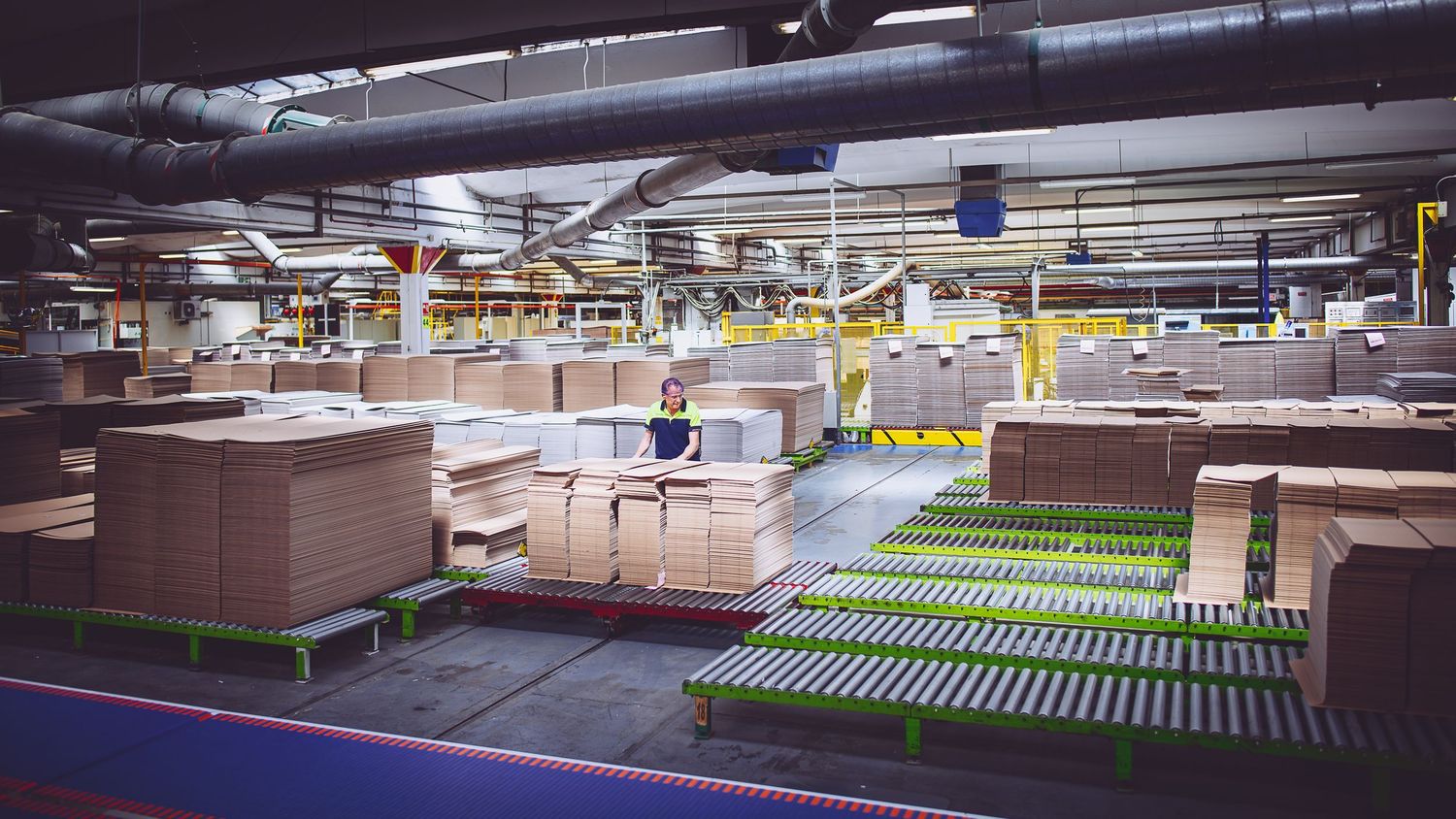 Panoramic view of a large warehouse distribution center with conveyor systems.