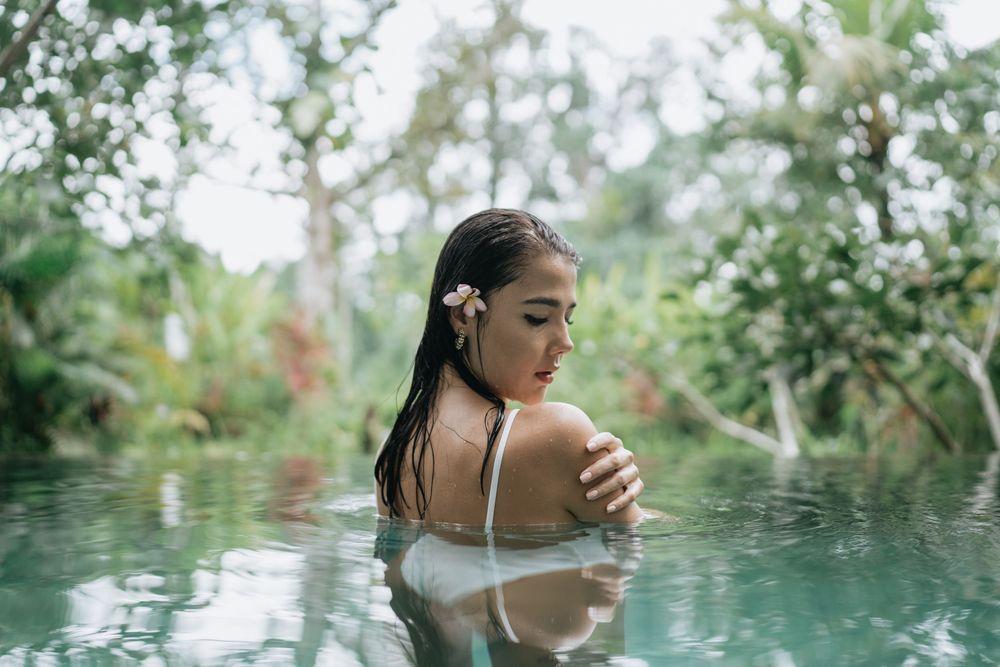 A serene moment captured in a tropical infinity pool with dense foliage in the background.