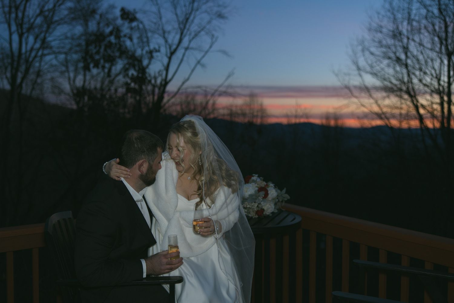 candid documentary photo of newly wed couple after mountain view wedding ceremony drinking champagne in their cabin