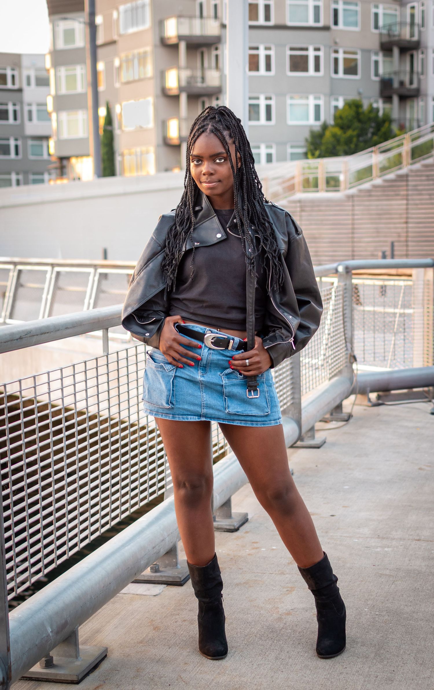 Model standing confidently in leather jacket and skirt at Seattle Waterfront during portfolio-building session.