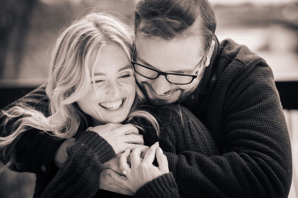 A romantic black and white photo series showing tender moments between a couple embracing and laughing together.