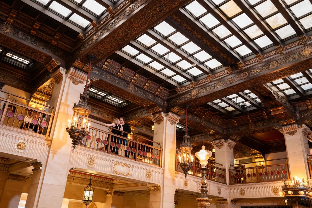 Architectural detail of a grand ballroom interior with wooden beams and skylights.