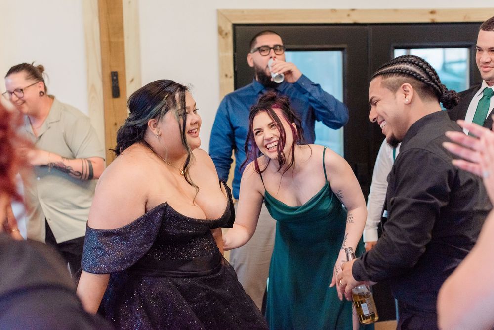 Dancing partners perform a slow dance during a social event in formal attire and cocktail dresses.