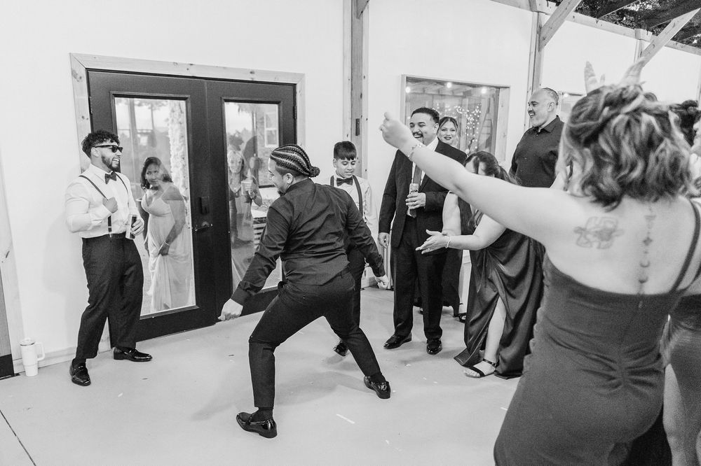 A group of people practicing swing dance moves in a bright dance studio space.