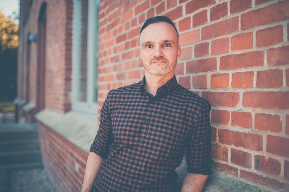 Multiple candid poses captured in front of a red brick wall during an autumn day photoshoot.