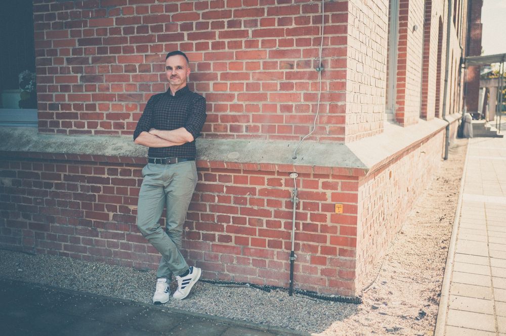 Five sequential photos showing a person climbing up and perching on a brick wall ledge in a casual urban setting.